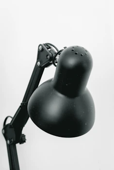 A stylish desk lamp with adjustable arms, highlighting a creative workspace with bright, focused light.