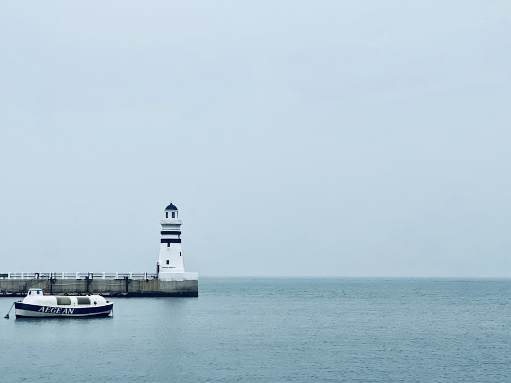 white boat near lighthouse