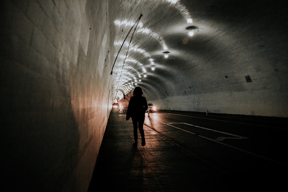 person standing inside tunnel