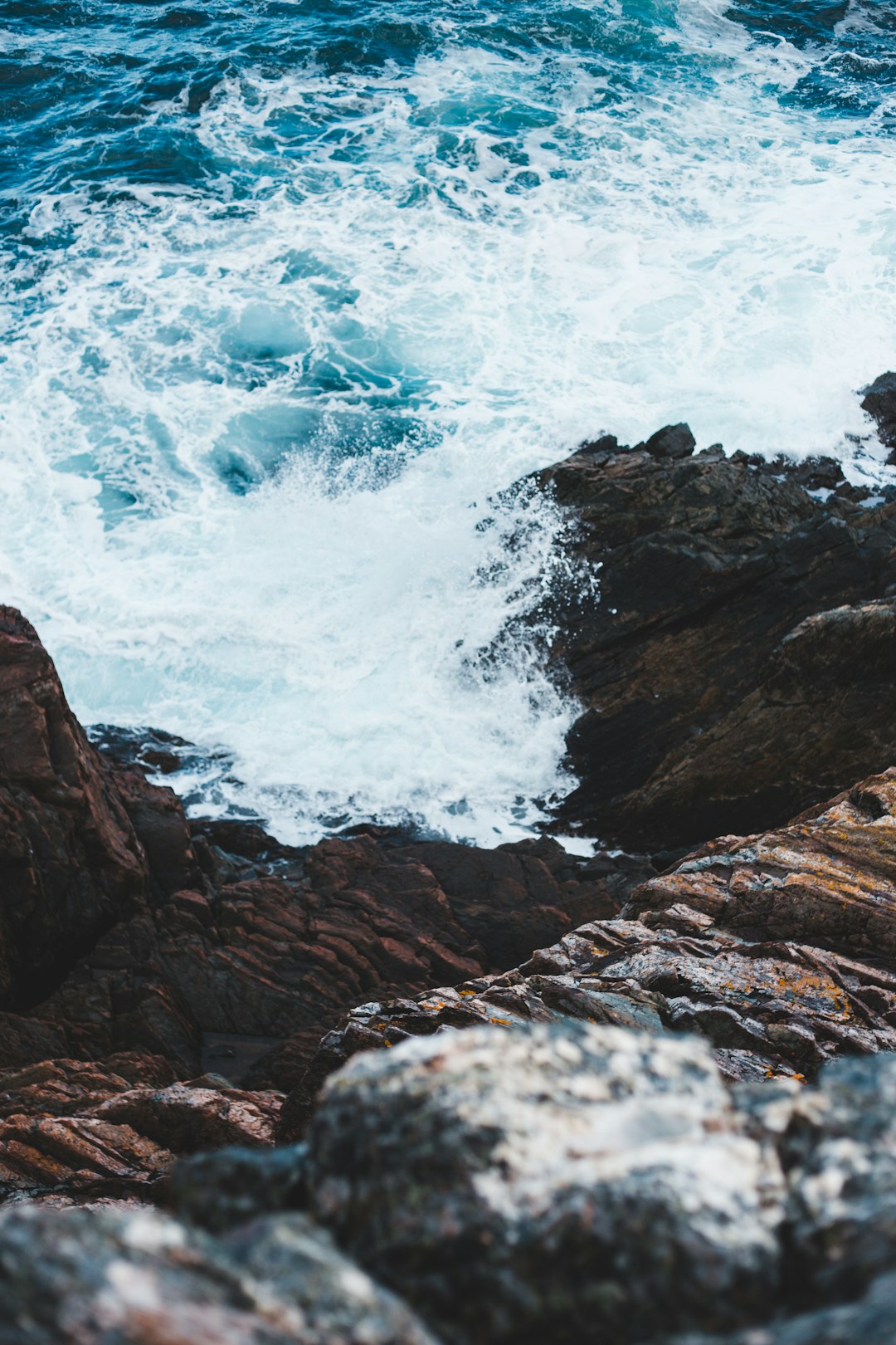 sea waves crashing on rocky shore during daytime