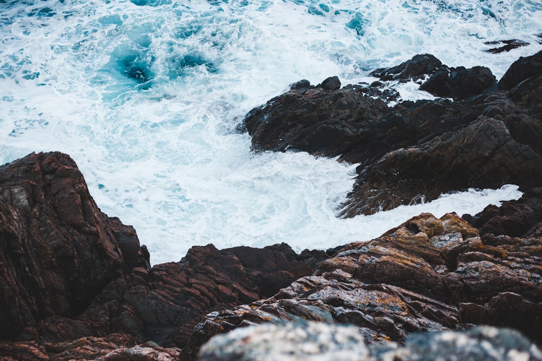 wave splashing on rock during daytime