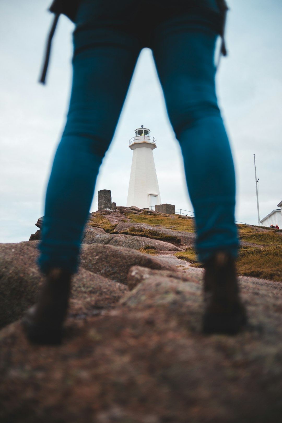 woman standing on rock near lighthouse