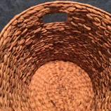 Close-up of artisan's hands weaving natural fibers into a basket.