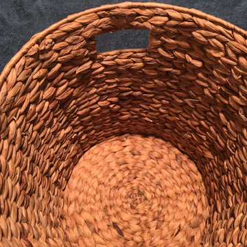 Close-up of artisan's hands weaving natural fibers into a basket.