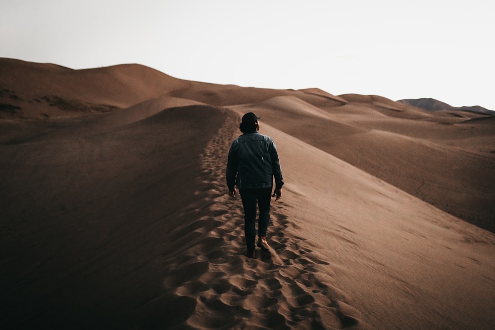 man walking on desert field