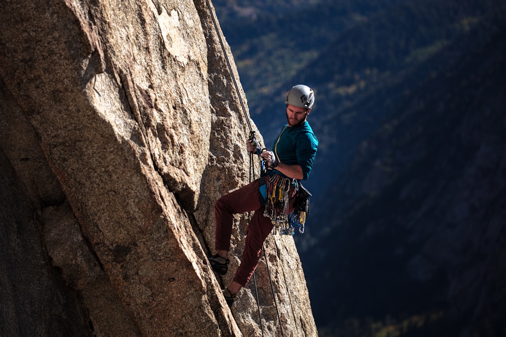 man climbing mountain during daytime