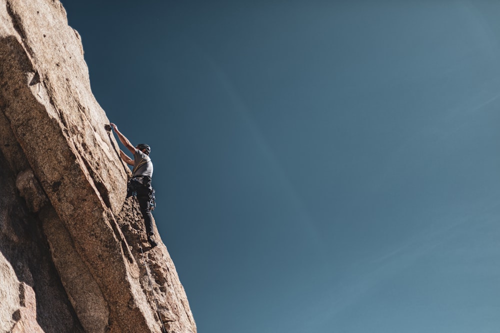 man climbing mountain during daytime