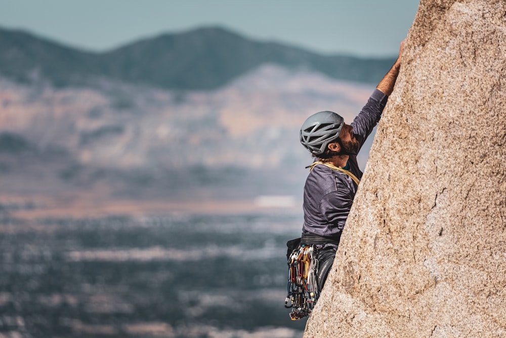 man rock climbing during daytime