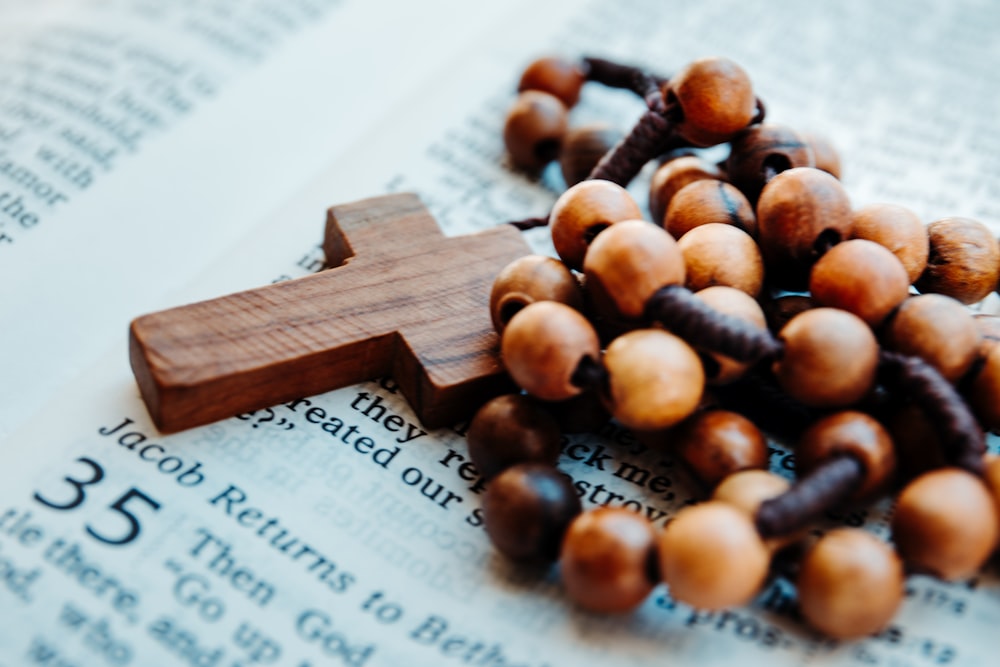 brown rosary on bible