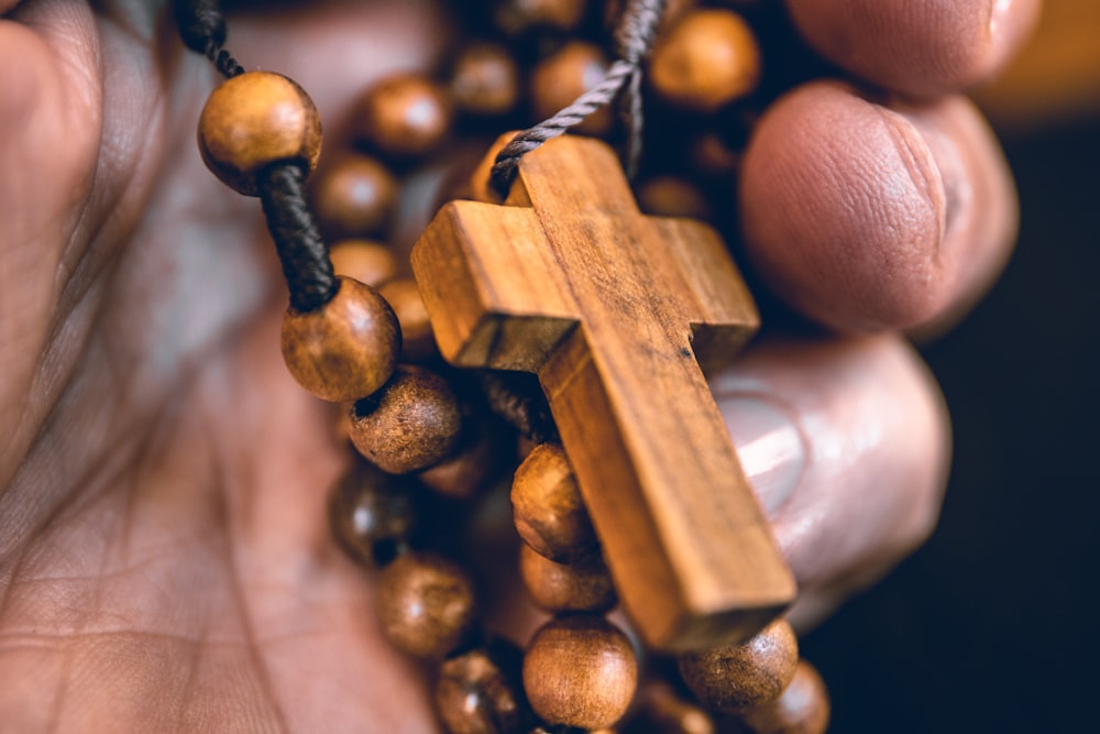 person holding beaded brown rosary