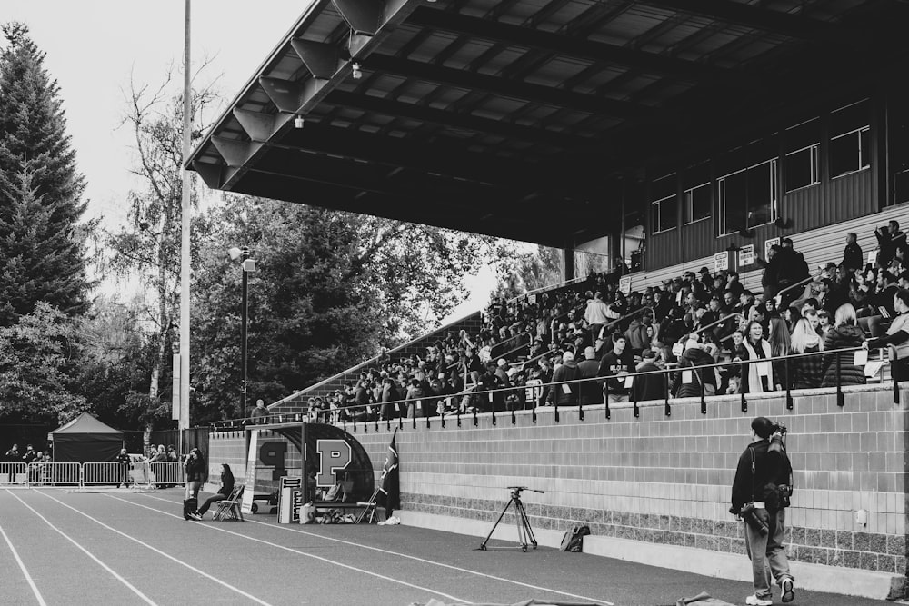 grayscale photo of man and woman at a stadium