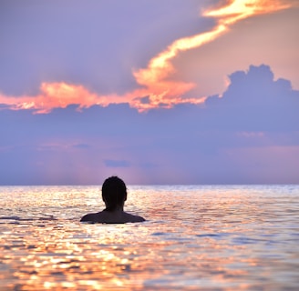 man swimming at siesta key beach at sunset