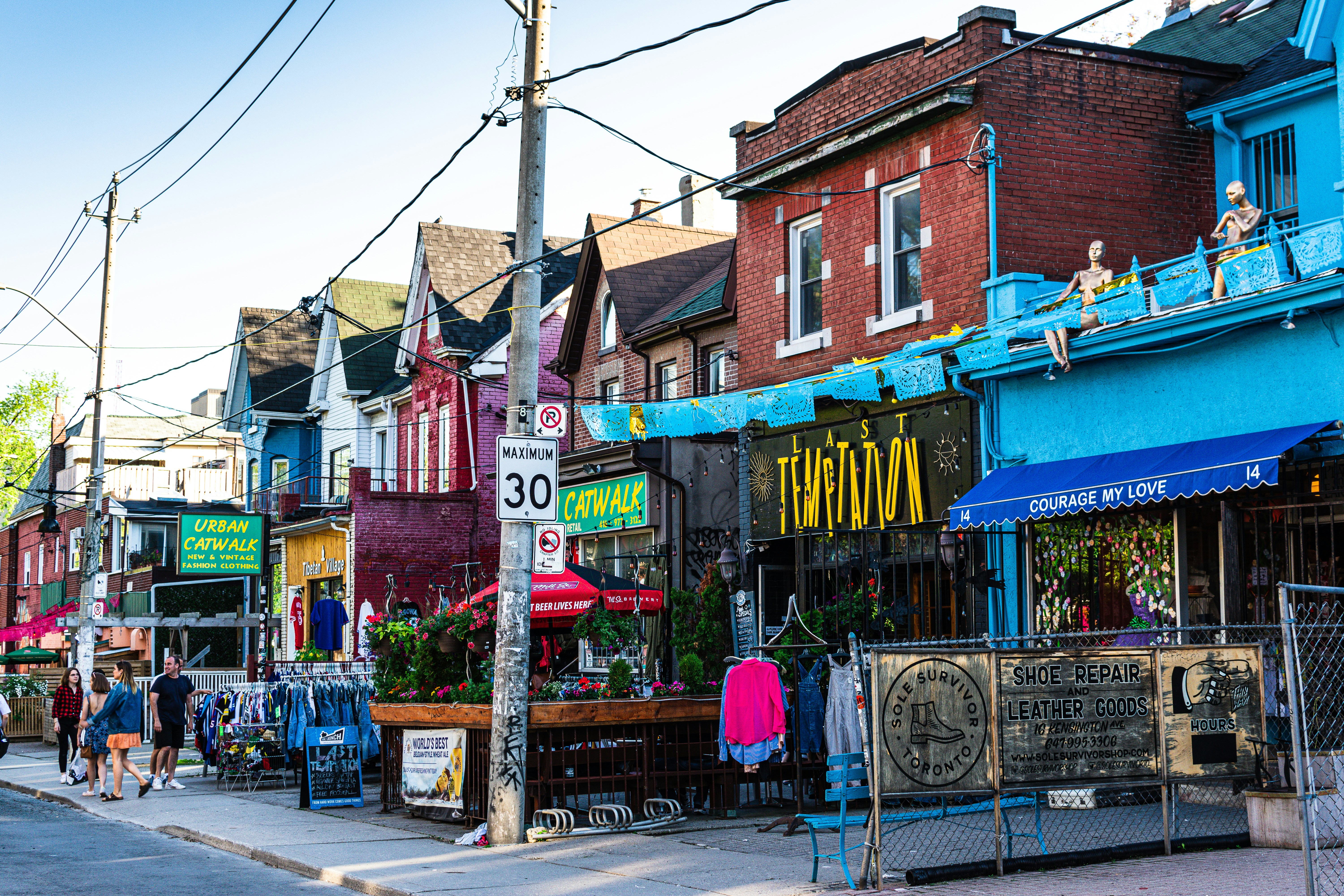 Colorful Kensington Market lane with shops, bikes and pedestrians in Toronto