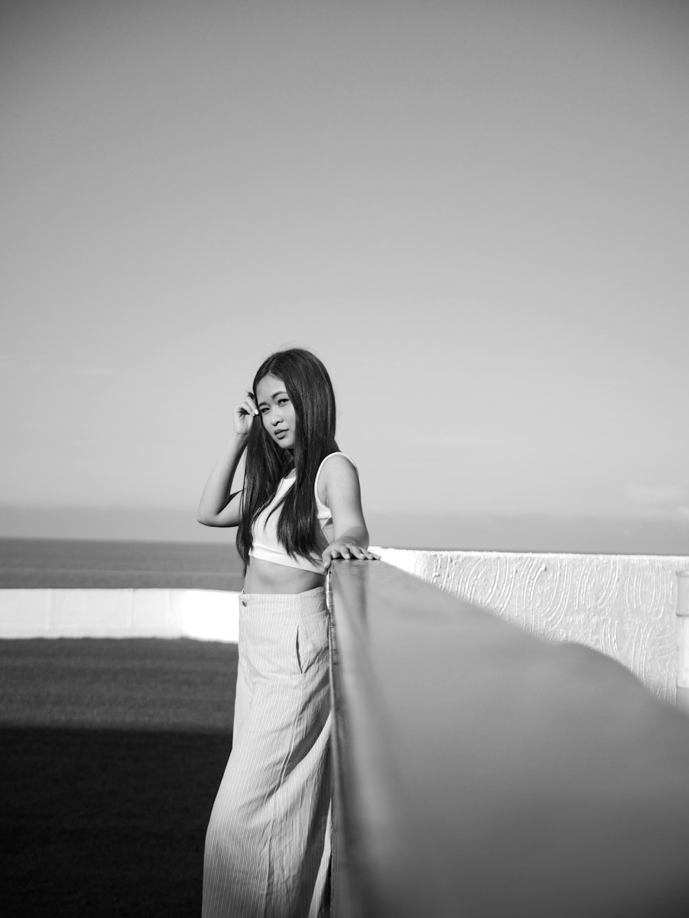 grayscale photo of woman leans on handrail