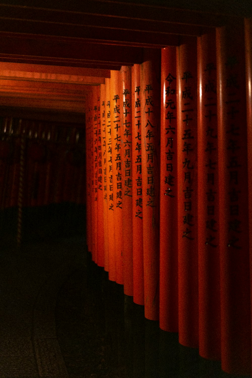 a row of red pillars with asian writing on them