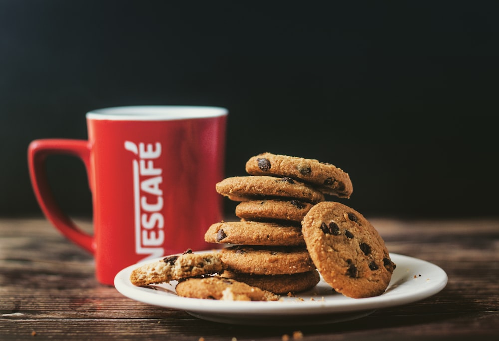 pile of cookies beside Nescafe ceramic mug