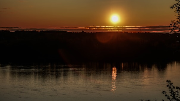 A sunset casting golden hues over the calm river waters.