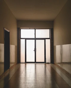 A frosted glass office door etched with the Prayter & Prayter, Ltd. logo, bathed in soft bone-colored light.