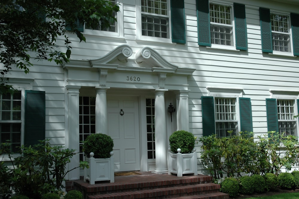 white concrete house near green bushes during daytime