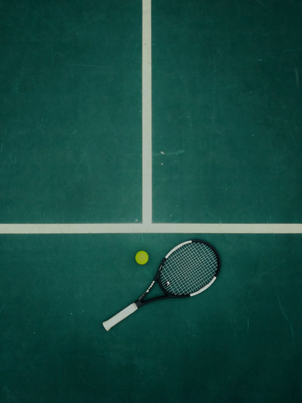 raqueta de tenis en blanco y negro junto a la pelota