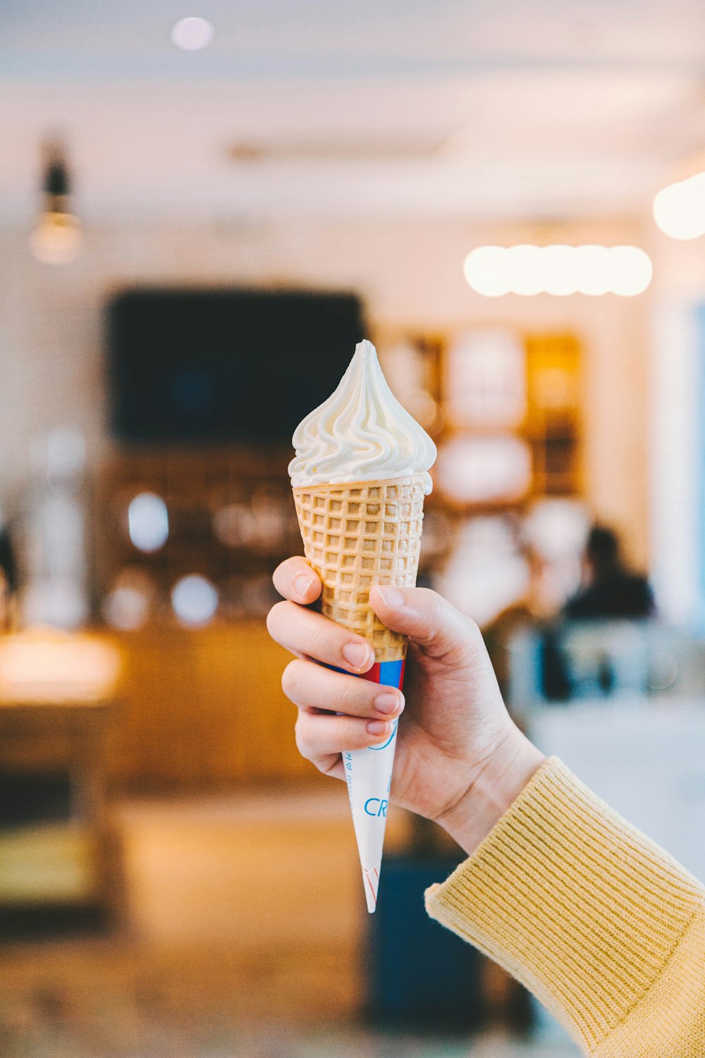 person holding cone of ice cream