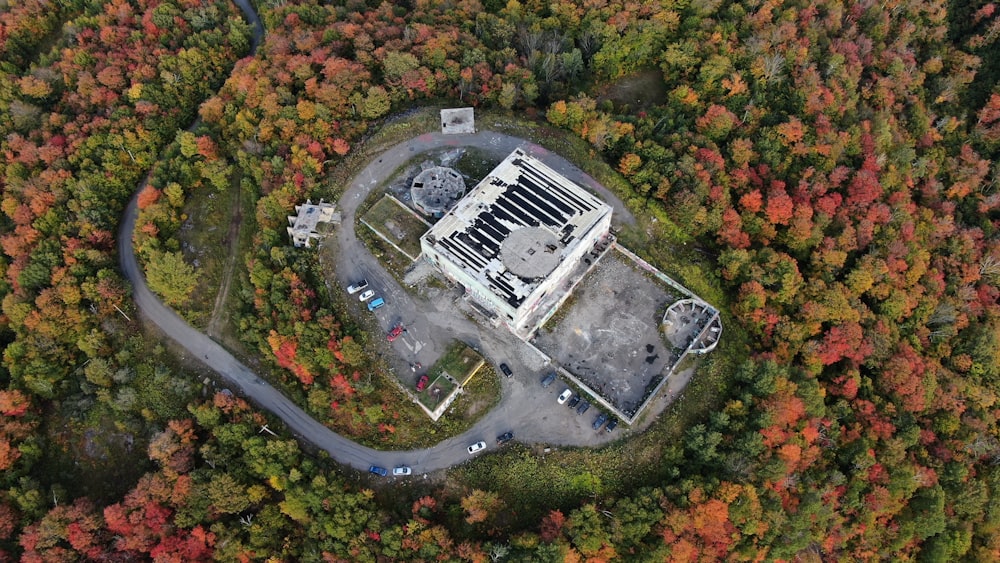 木々に囲まれた白いコンクリートの建物の航空写真