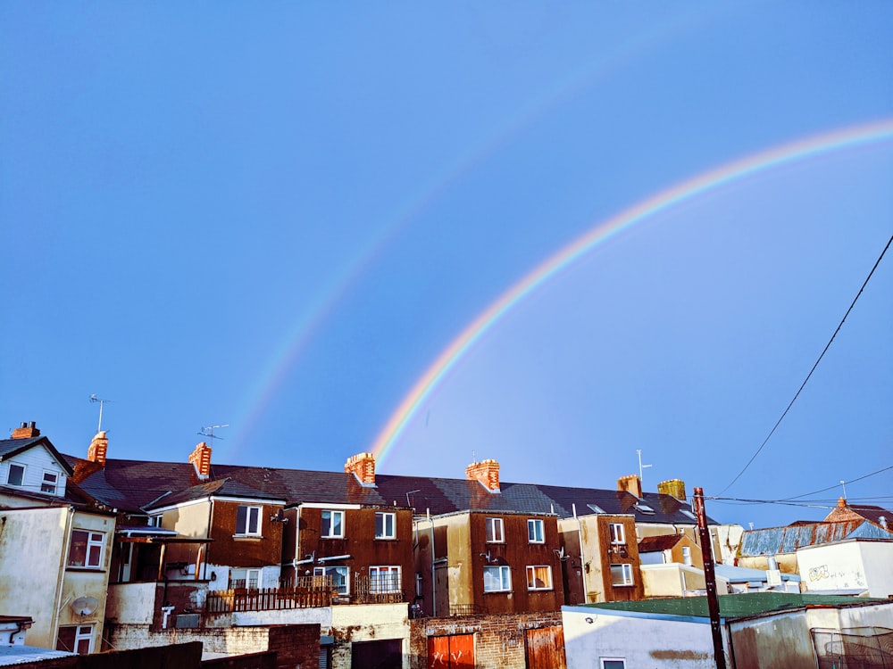 maroon houses under rainbow