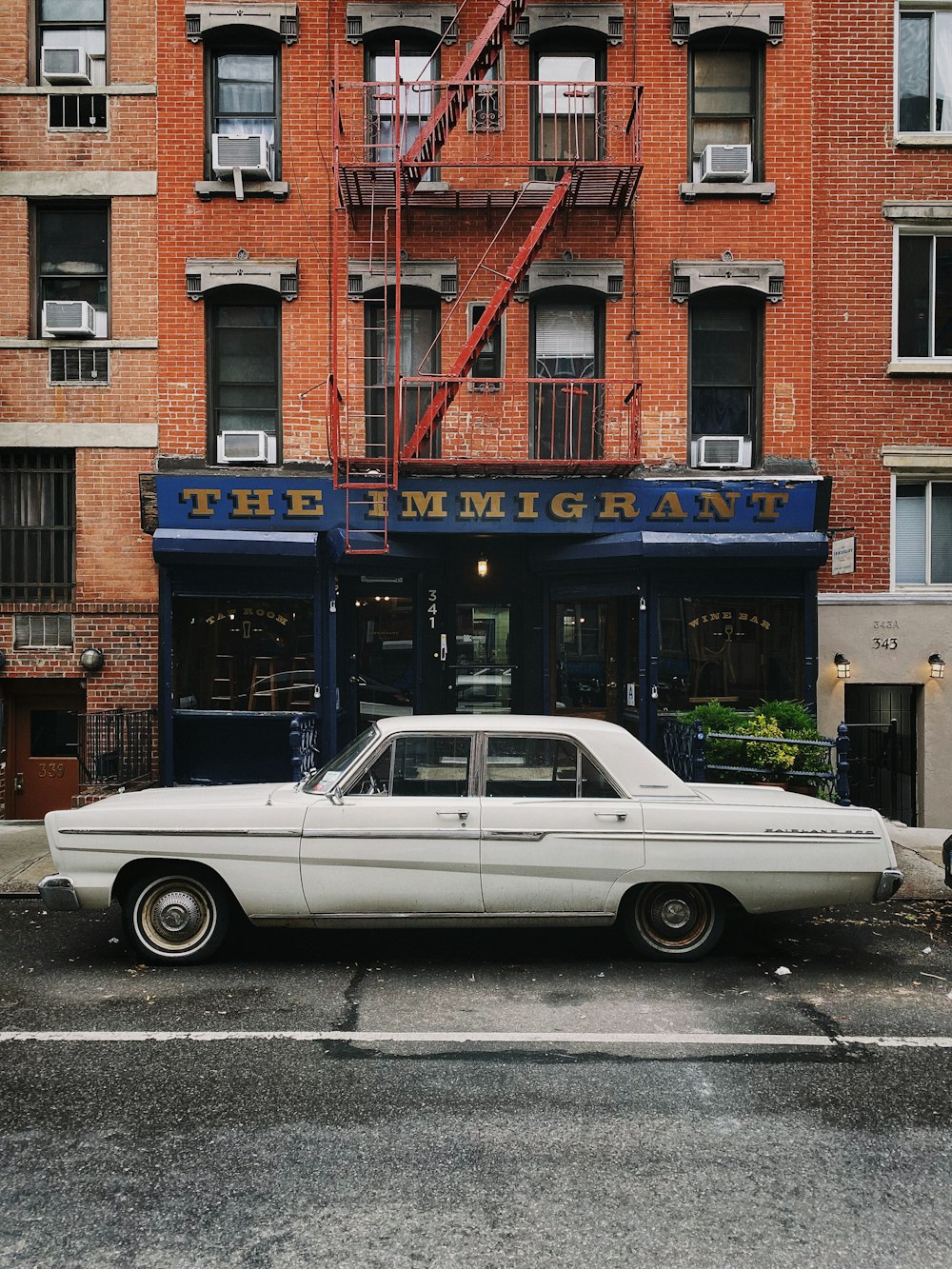 white sedan parked in front of concrete building