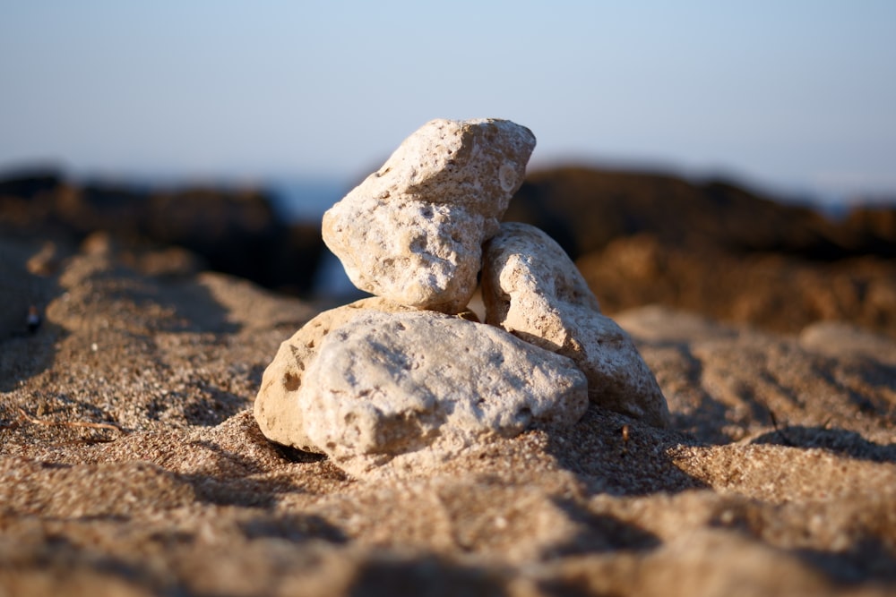 four rocks on sand