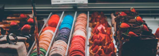 Assortment of colorful macarons and pastries illuminated by soft neon glow