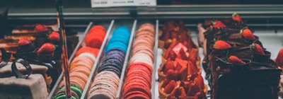 Assortment of colorful macarons and pastries illuminated by soft neon glow