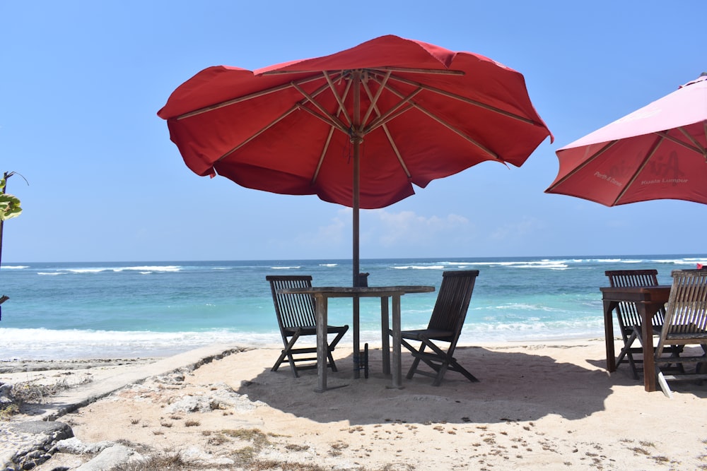 una mesa y sillas bajo una sombrilla en la playa
