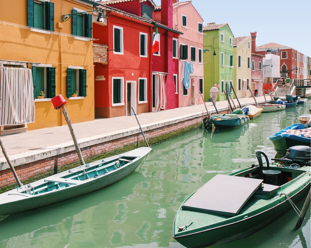 empty boats on canal near assorted painted houses