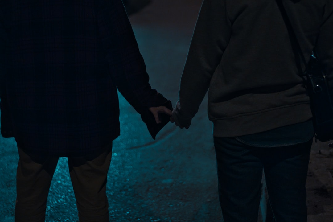two person holding hands each other