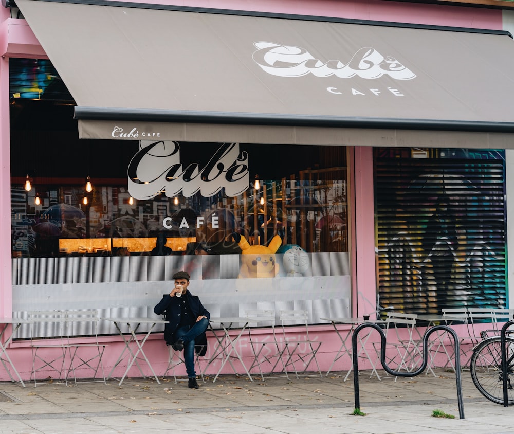 man sitting outside cafe while drinking coffe