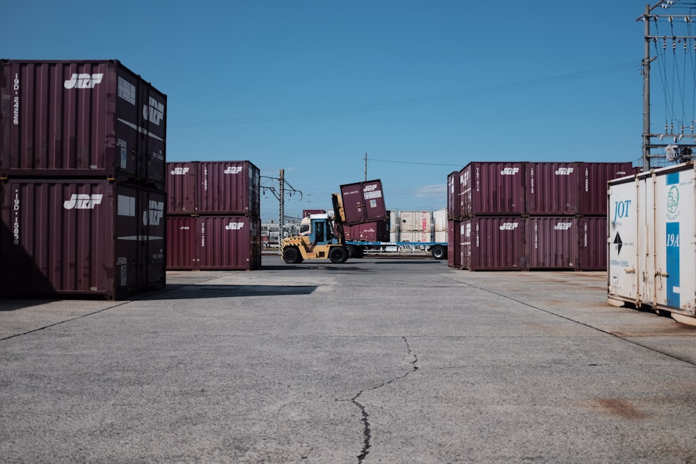 maroon shipping containers under blue and white sky during daytime