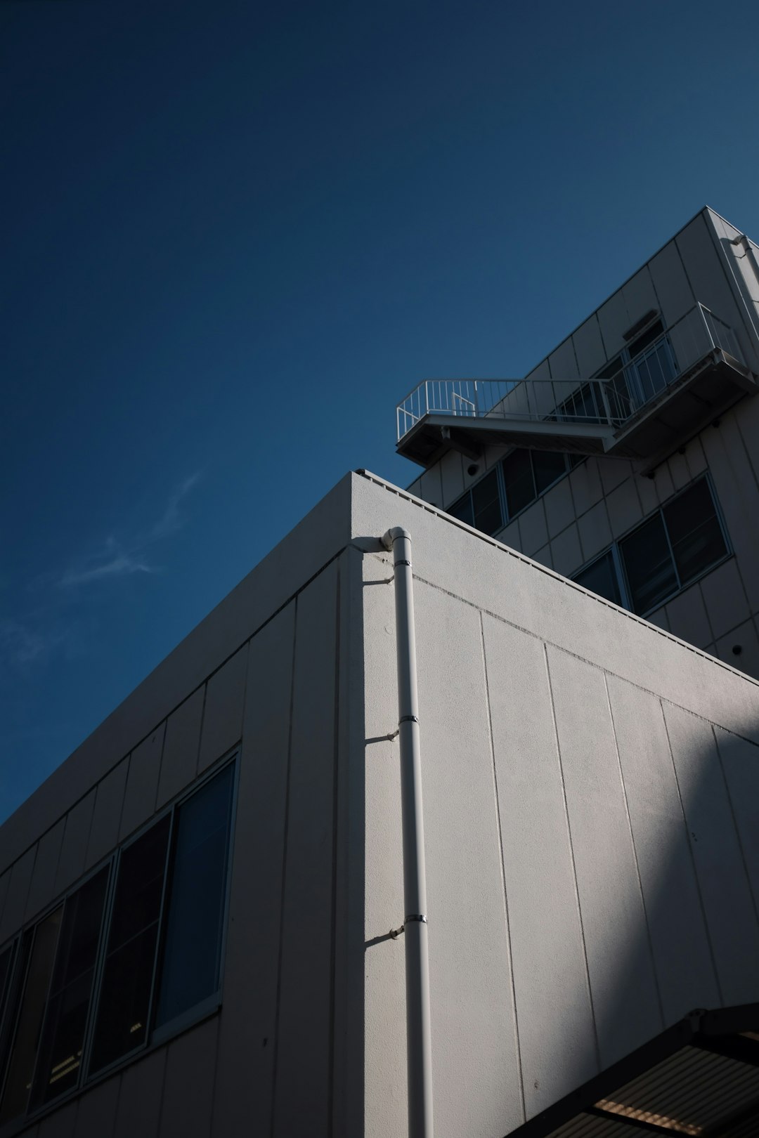 low-angle photography of gray concrete building under clear blue sky