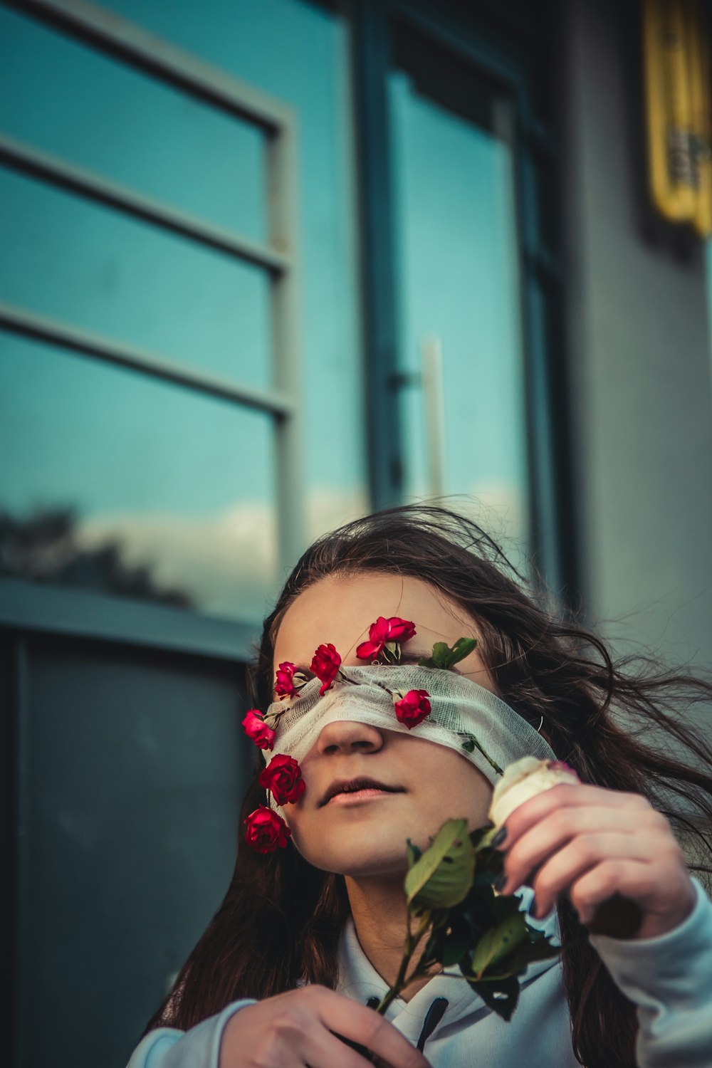 woman with blindfold and red roses on tip