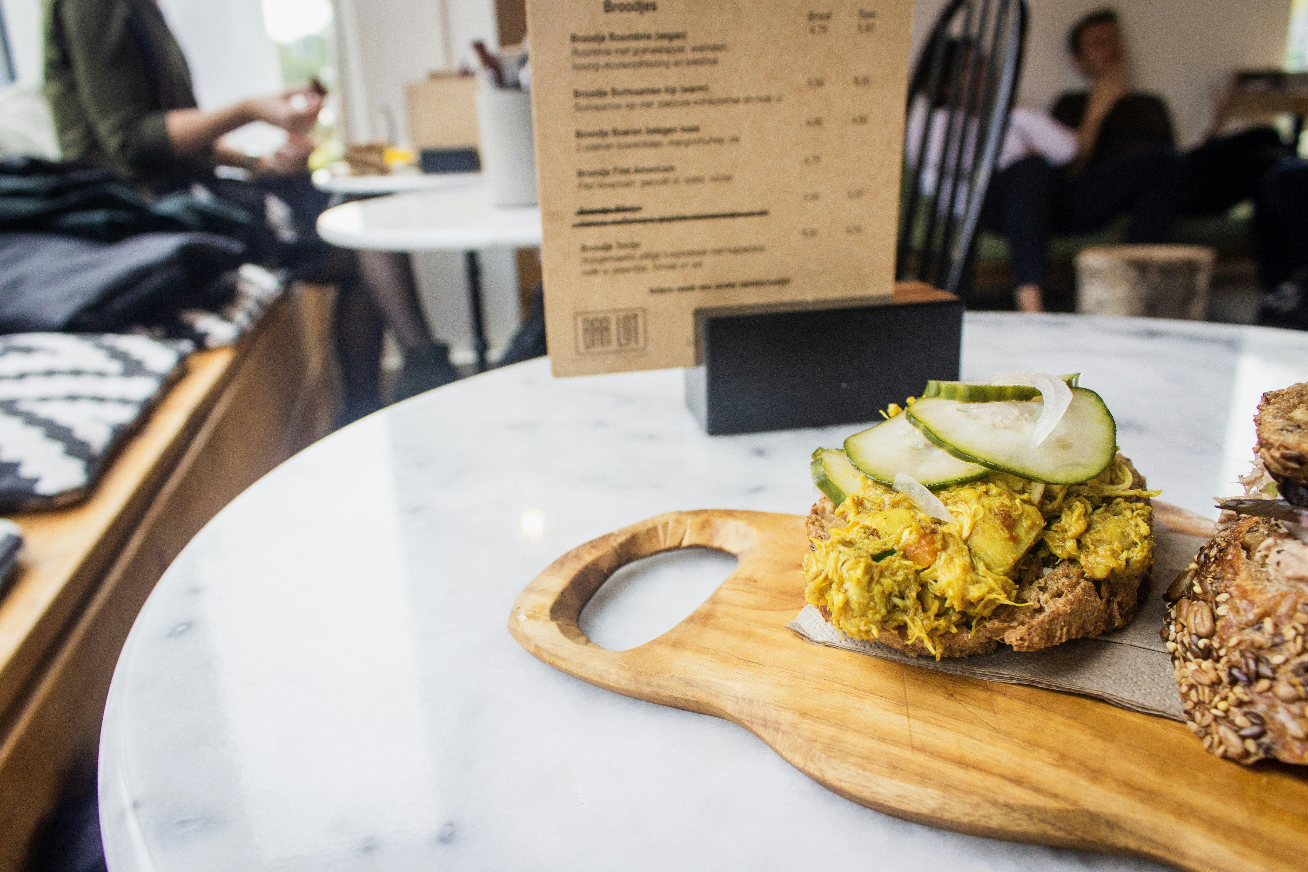 Smashed avocado toast on a board in a cafe