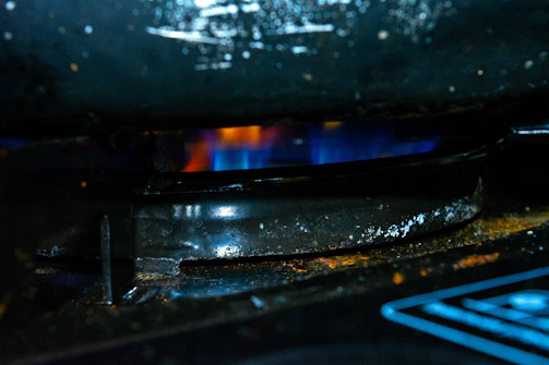 Close-up of a kitchenfix technician adjusting stove burners during maintenance.