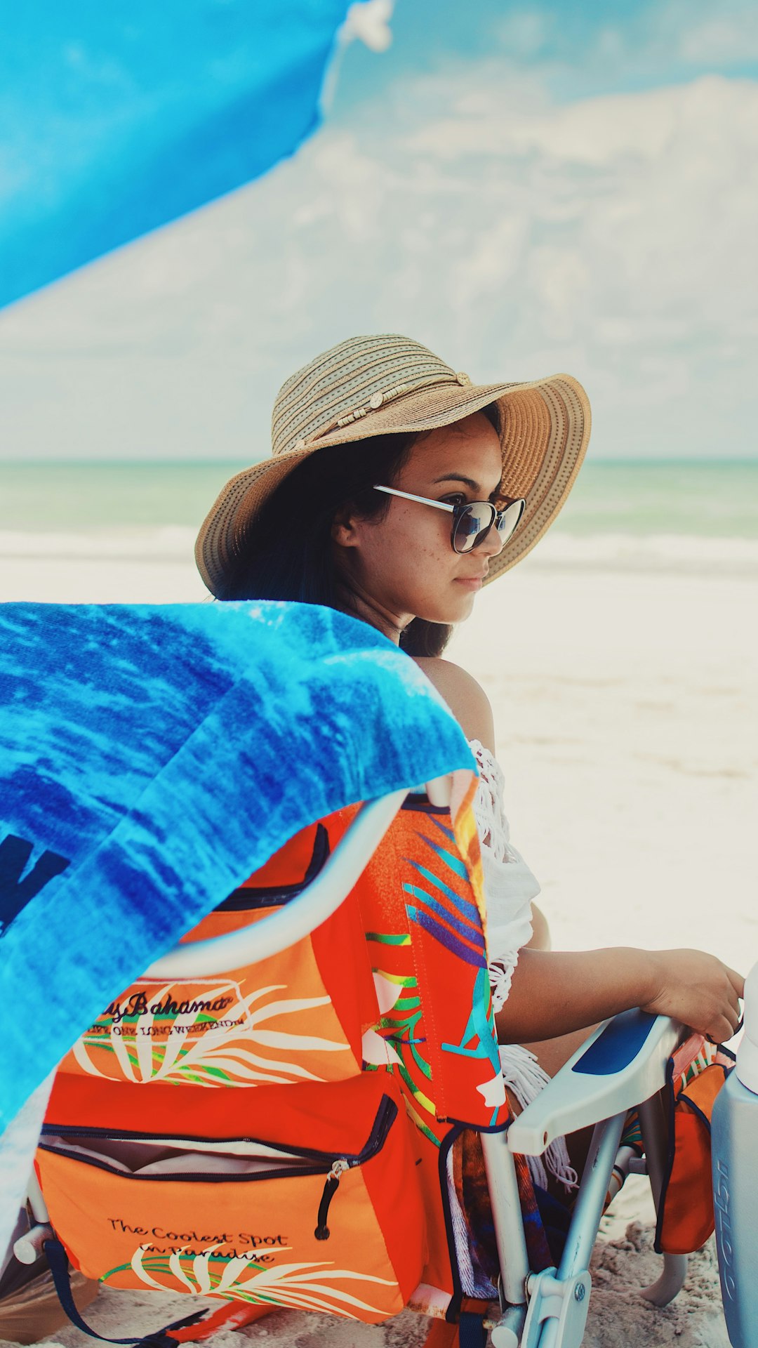 woman sits on sunlounge at the beach