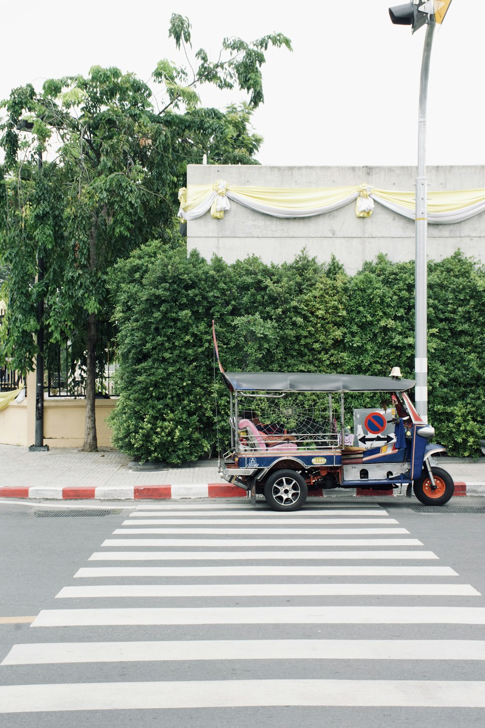 blue and white auto-rickshaw on pedestrian lane