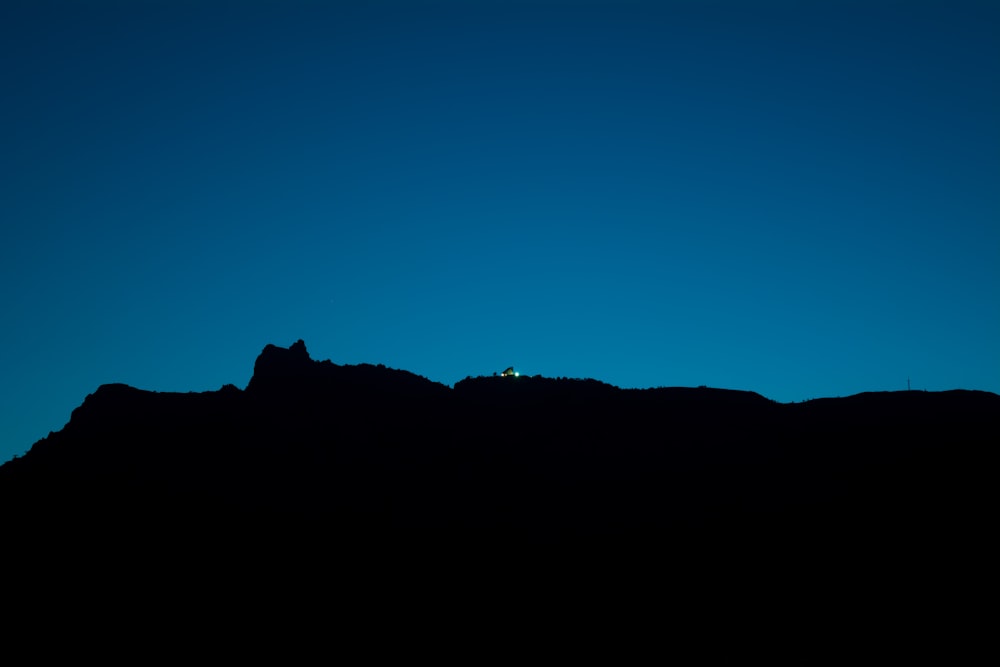 silhouette view of mountain on blue background