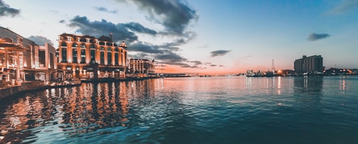 Elegant waterfront luxury condo at sunset with golden hues reflecting on the water.