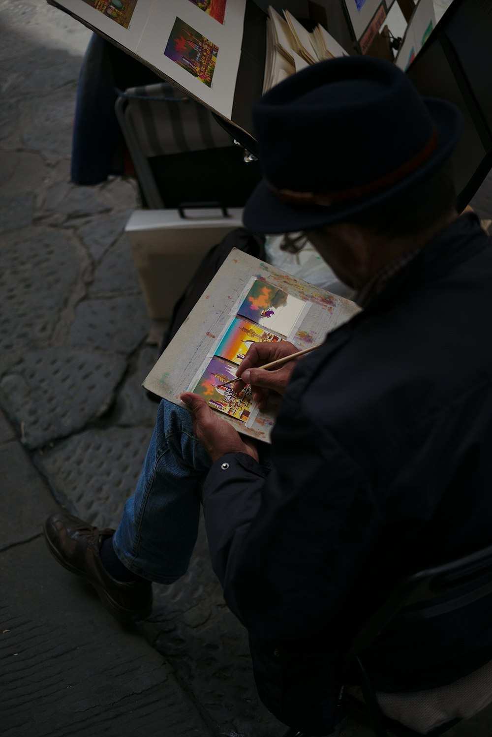 man in hat and jacket holding color palette