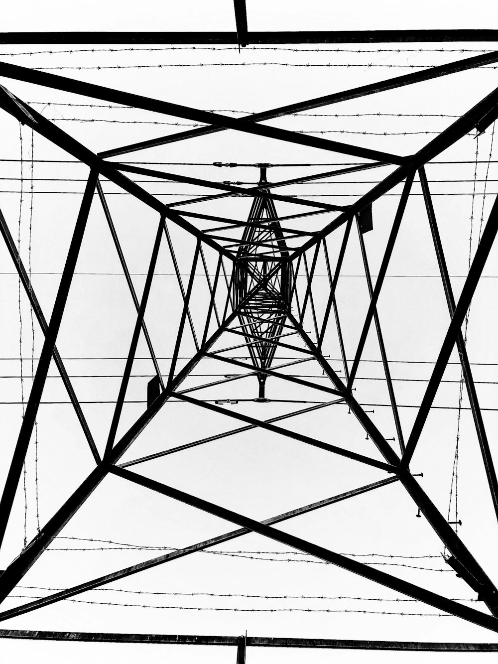 a black and white photo of a high voltage tower