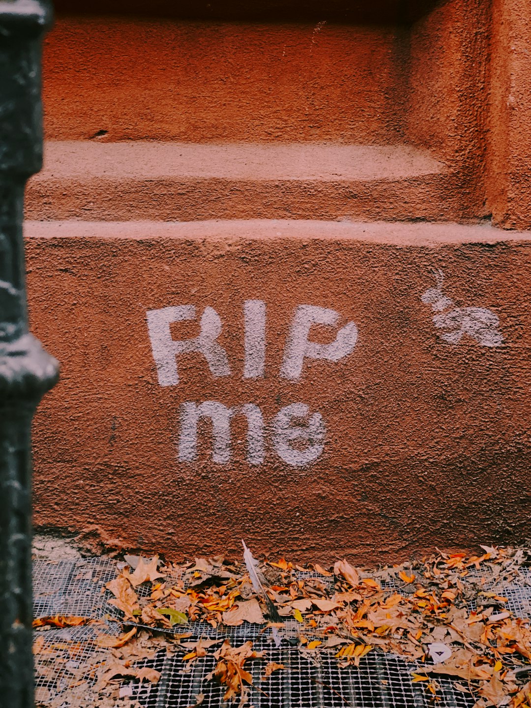 rip me text printed on red concrete wall