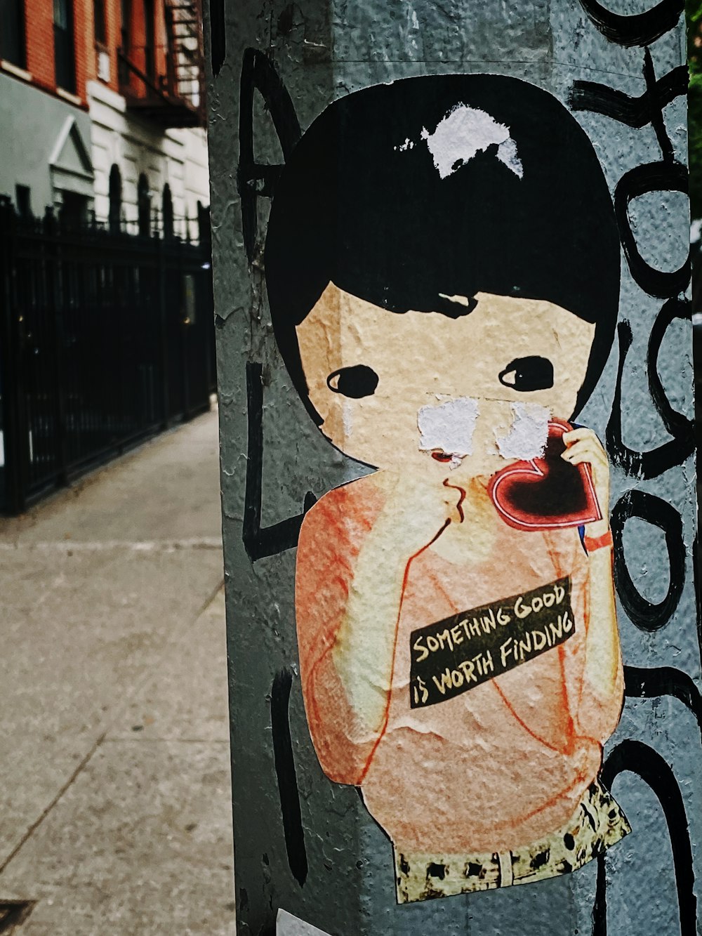 woman in brown shirt holding heart graffiti