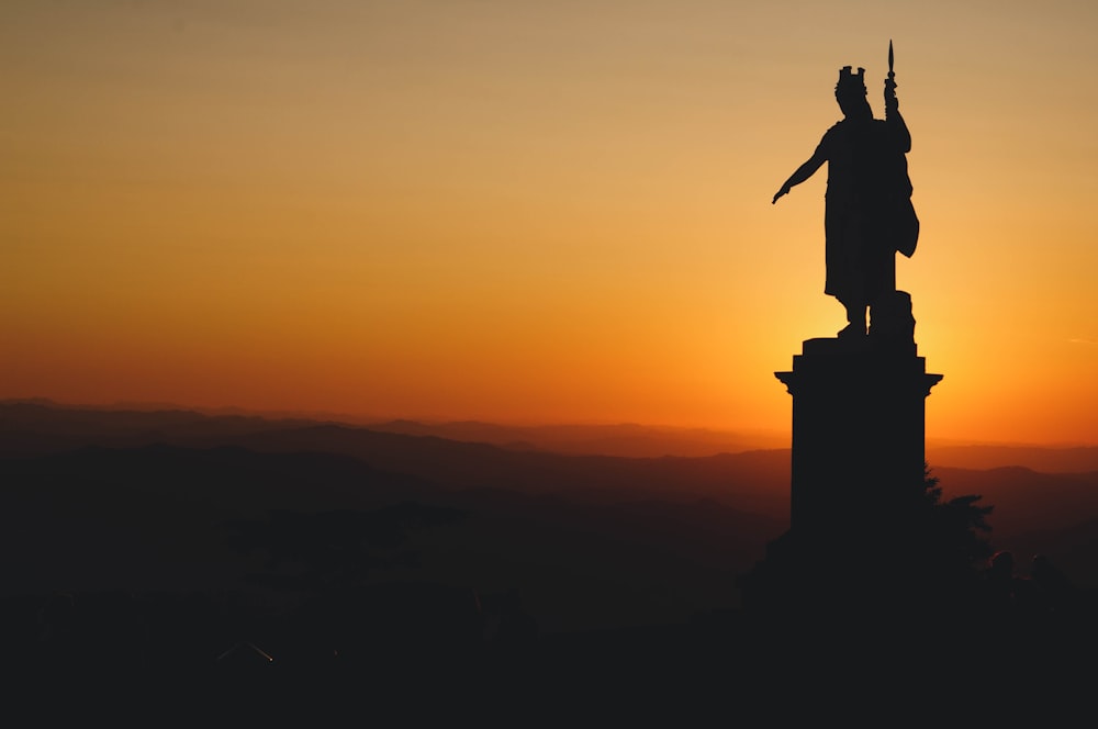 the statue of liberty is silhouetted against a sunset