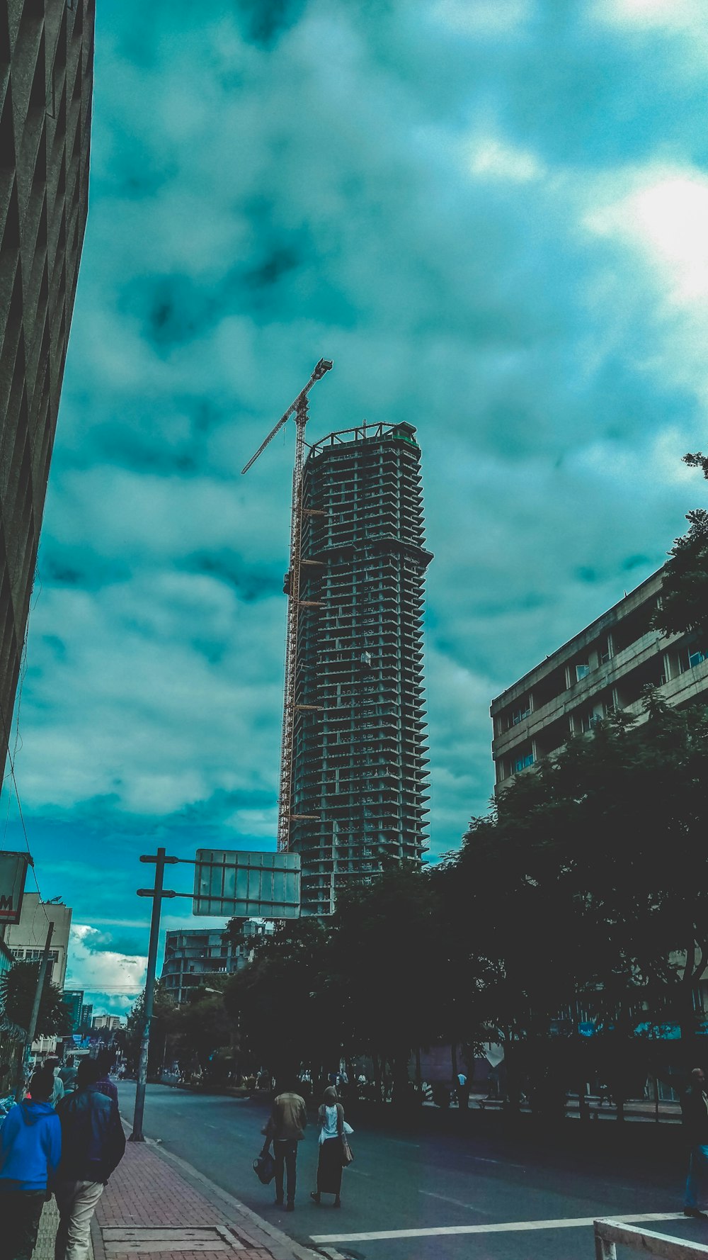 people walking on pathway near buildings under blue and white sky during daytime